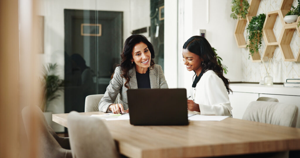 Two business professionals reviewing an embedded finance integration on a laptop during a meeting