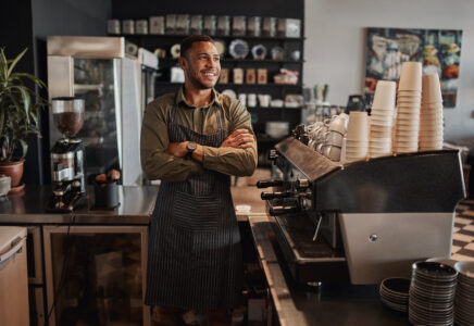 Small business owner behind an espresso machine who uses Flute's new payment platform for his merchant services