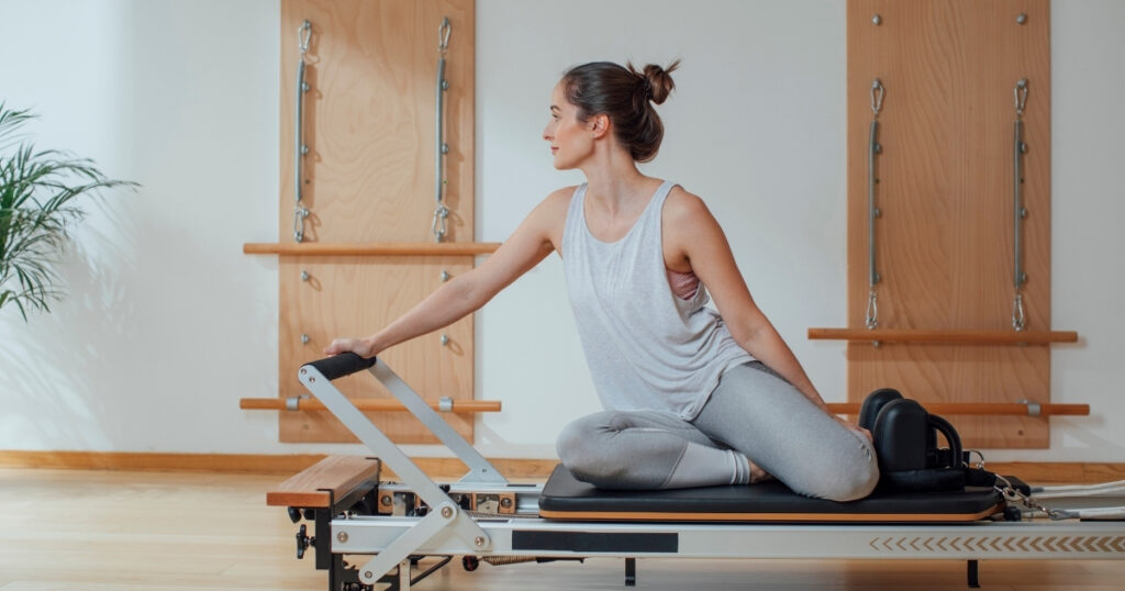 Client using a reformer at a wellness studio that uses cash discounting to reduce credit card processing fees