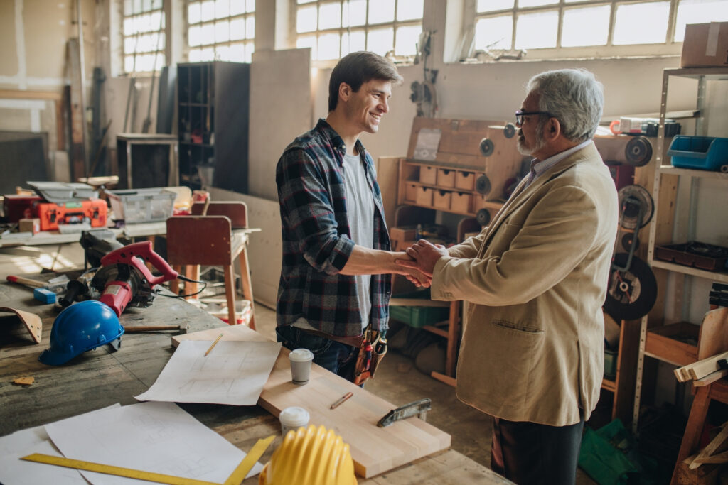 ACH Payments 101: A Small Business Guide to Bank Transfers 2 Contractor and client shaking hands after agreeing to settle a large B2B invoice by bank transfer