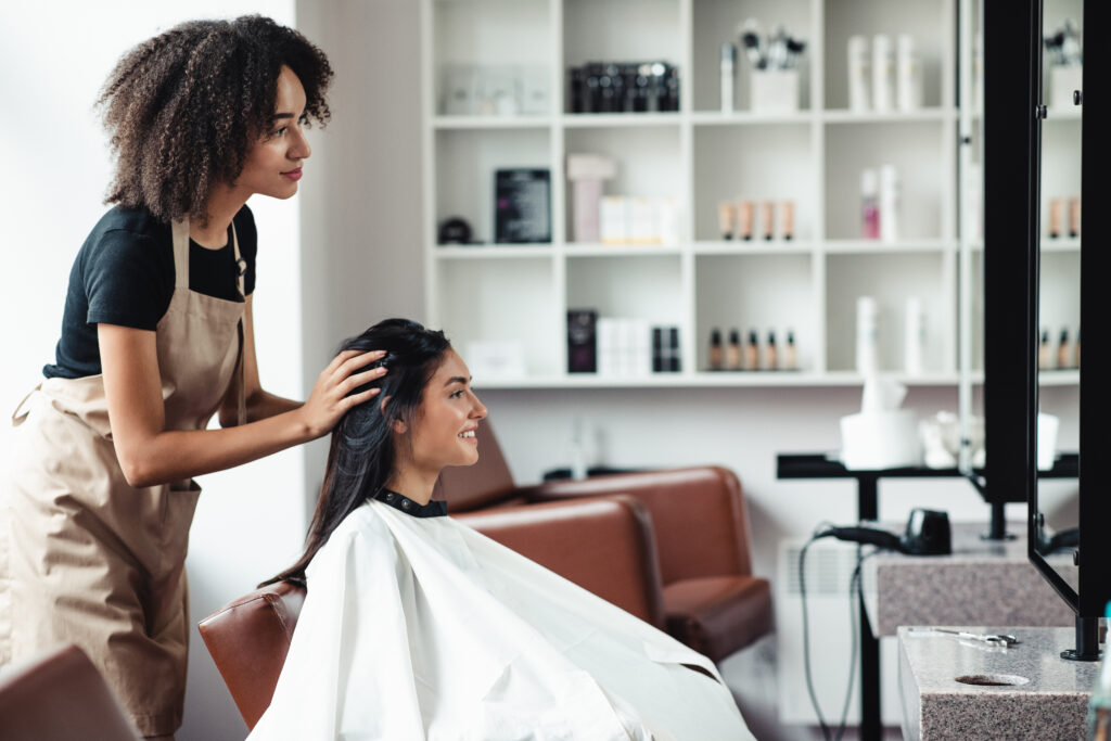 Recurring Payments: A Guide to Steadier Business Revenue 1 A hairstylist styles a client's hair at a salon that bills regulars through a monthly membership package.